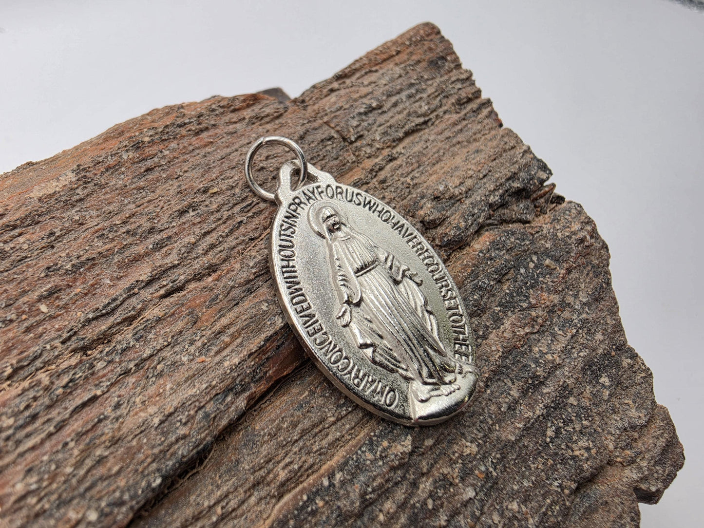Sterling silver Miraculous Medal pendant — oval with engraved Virgin Mary figure and the prayer text around the border, bail included